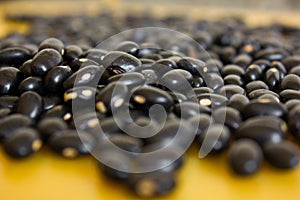 Food item - black beans grains with a warm and yellow background