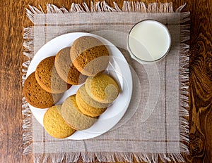 Food, junk-food, culinary, baking and eating concept - close up oatmeal cookies and milk glass