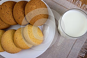 Food, junk-food, culinary, baking and eating concept - close up oatmeal cookies and milk glass