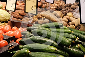 Food market vegetables with price tag. Various fresh ripe cucumbers, tomatoes, potatoes and other agricultural products