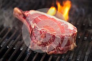 Food meat - beef steak on bbq barbecue grill with flame