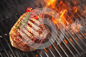 Food meat - beef steak on bbq barbecue grill with flame