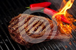 Food meat - beef steak on bbq barbecue grill with flame