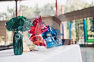 Food and other grocery items wrapped in green, red, and blue water cellophanes and flower ready on the table for offertory