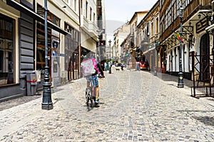 A Food Panda food delivery courier on a bike in Old Town of Bucharest, Romania, 2020. Food deliveries by bike couriers due to