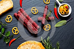 Food party background BÃ¢ton Ã  Croquer french dried beefs stick, olive, prezels and homemade bread on black slate stone