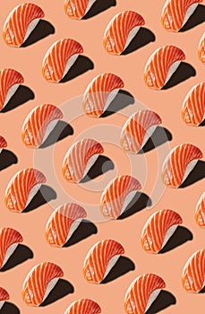 Food pattern of nigirizushi with salmon on pinkish background