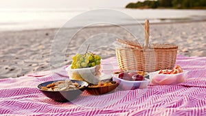 Food and picnic basket on blanket on beach