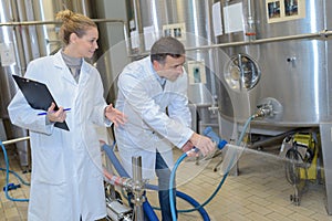 Food plant worker cleaning stainless steel tank