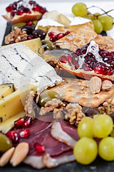 Food Platter With Truffle Cheese, Duck Breast, Brie Cheese, Pecan Nuts, Pomegranate Seeds, Grapes, Almonds, Honey, Olives