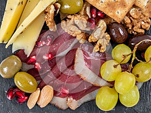 Food Platter With Truffle Cheese, Duck Breast, Brie Cheese, Pecan Nuts, Pomegranate Seeds, Grapes, Almonds, Honey, Olives