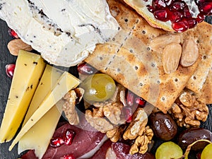 Food Platter With Truffle Cheese, Duck Breast, Brie Cheese, Pecan Nuts, Pomegranate Seeds, Grapes, Almonds, Honey, Olives