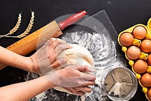 Food preparation concept over head shot Kneading dough for bakery, pizza or pasta on black background with copy space