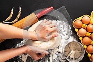 Food preparation concept over head shot Kneading dough for bakery, pizza or pasta on black background with copy space