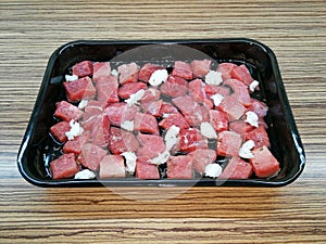 Food preparation, pieces of meat inserted in a baking tray, with lard and water