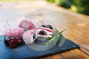 Food presentation slate tray with ice cream and cherries on wooden table. Mochi asian dessert