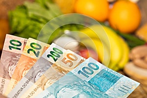 Food prices in Brazil, Economic concept, File of Brazilian money reais against the background of different types of food products