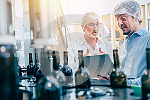 Food production process inspector team working in beverage bottle conveyor line