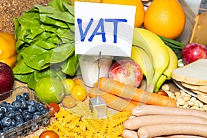 Food products and a sign with the inscription Vat tax in Polish Concept, Restoration of VAT on food in Poland. Increase in