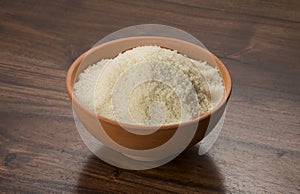 Food: Raw Unrefined Cane Sugar in Earthen Bowl on Wooden Background Shot in Studio