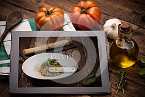 Food recipes tablet computer on rustic wooden table