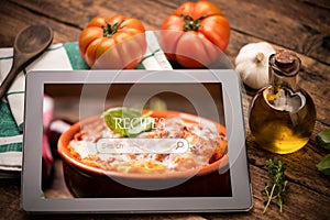 Food recipes tablet computer on rustic wooden table