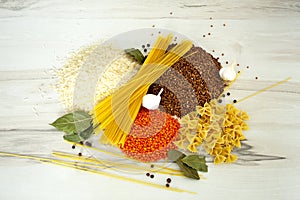 Food: rice, buckwheat, spaghetti, pasta, lentils and garlic with peper on the table