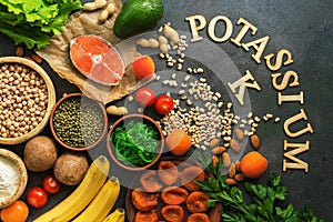 Food rich in potassium, salmon, legumes, vegetables, fruits, nuts on a dark background. Healthy food concept, avitaminosis