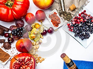 Food rich with resveratrol, grapes, pomegranate, green tea on sackcloth, physalis, cranberry, cherry, tomatoes, goji, peanuts,