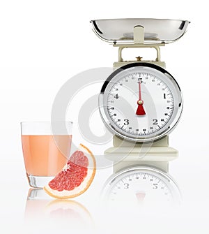 Food scale with grapefruit juice glass isolated on white background