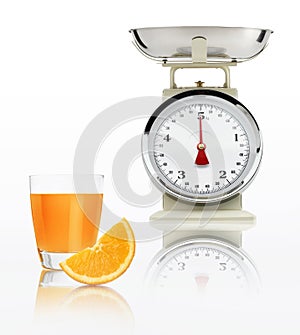 Food scale with orange juice glass isolated on white background