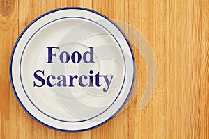 Food scarcity on empty plate on a wood table