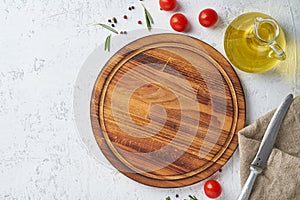 Food seasoning background. Round wooden cutting board, spices, herbs on white concrete backdrop. Top view, copy space. Menu,