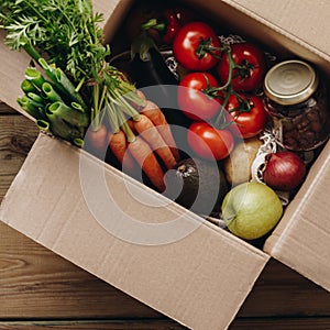 Food selection in paper box: fruit, vegetable, herbs, legumes, cereals, leaf vegetable on wooden background