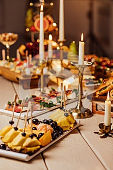 food on the served festive table. fruit platters, cheese, canapes and cold cuts for the buffet. Catering.