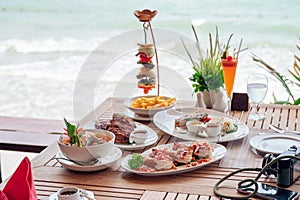 Food with Shrimp spicy, Fried pork ribs, Tom yum goong, Beef steak on wooden dining table in tropical sea