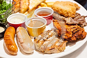 Food Steaks and Sausages Assortment Spicy Chicken, Pork, Beef, Fish served with French Fried and baked bread, sided with