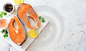 Food stone background with raw salmon steaks  sea salt  peppers and lemon