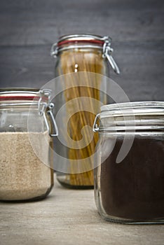 Food storage. Food ingredients in glass jars, on wood background.