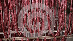 Food storage, warehouse. Meat products, sausages hanging on racks in a meat warehouse, freezer.