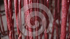 Food storage, warehouse. Meat products, sausages hanging on racks in a meat warehouse, freezer.