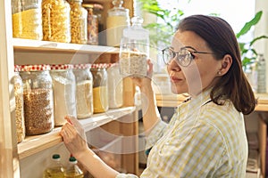 Food storage, wooden shelf in pantry, woman taking food for cooking