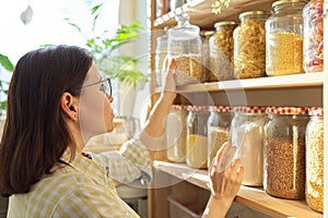 Food storage, wooden shelf in pantry, woman taking food for cooking