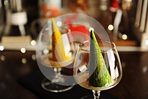 Food styling of Italian dessert afogato as Christmas tree with shining star. Inverted green waffle cone in cognac glass