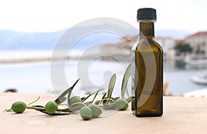 Food styling of olive oil bottle and olives on marble table.Blurred background