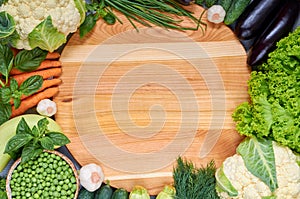 Food summer background with copy space for text. Fresh organic vegetables around wooden board. Raw ingredients for salad, soup