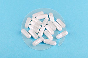 Food supplement capsules on blue background closeup