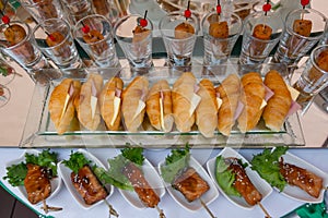 The food on the table includes croissants, sausages, grilled pork