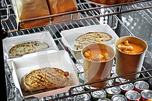 Food to go on display window chicken sandwich, salmon sandwich,  soup