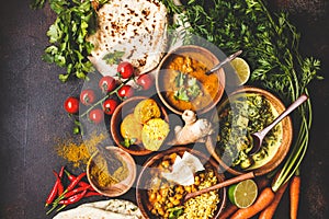 Food traditional Indian cuisine. Dal, palak paneer, curry, rice, chapati, chutney in wooden bowls on dark background